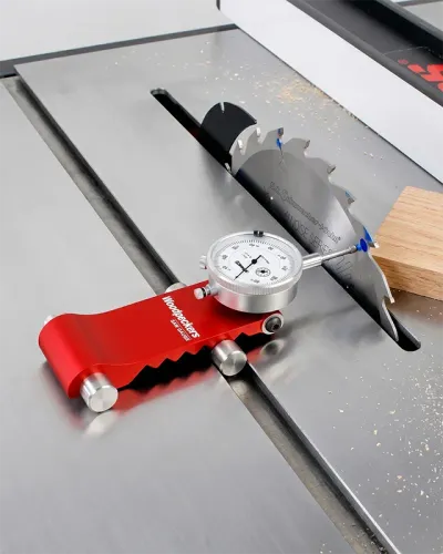 A dial indicator mounted in the miter slot measuring the lateral runout of a table saw blade